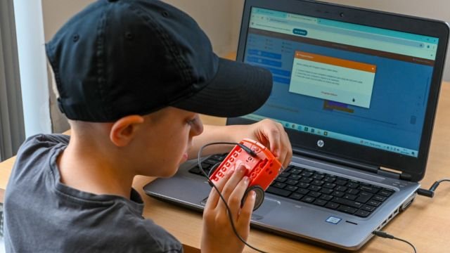 student looking at edison robot